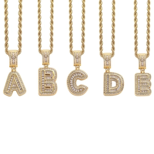 Detailed macro of gold hip hop pendants A to E encrusted with cubic zirconia stones