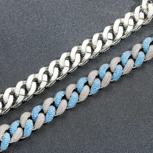 Detail of 14mm Cuban link bracelets with blue and white pavé-set stones on black background