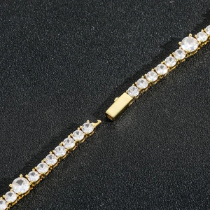 Close-up detail of golden tennis bracelet with cubic zirconia and secure clasp connector