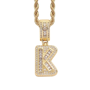 Detailed close-up of golden letter K pendant with ice square cubic zirconia stones