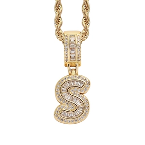 Detailed close-up of hip hop pendant letter S with square zircons on gold rope chain