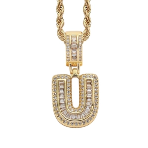 Close-up of hip hop gold letter U pendant with iced out baguette and round zircons