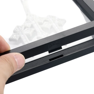Detailansicht des PUSH-Druckknopfes an einer schwarzen PE-Folie Schmuck-Display-Box