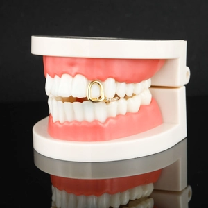 Hip hop gold plated grillz with zircon stones on teeth model in black background