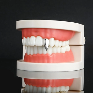 Zilveren vampiertand grillz detail op tandmodel met een spiegelende afwerking