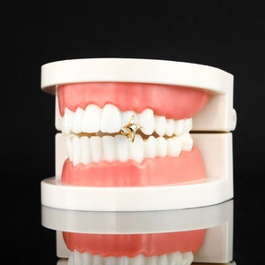 Hip hop style gold star grillz with embedded cubic zirconia on a single tooth display