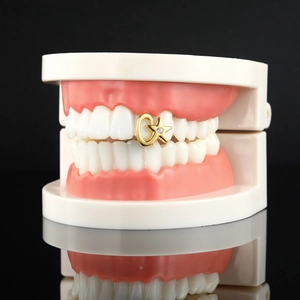Detail of hip hop gold grillz featuring star and moon design with inlaid zircon