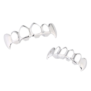 Macro detail of silver vampire fangs grillz set with polished metallic finish for costume