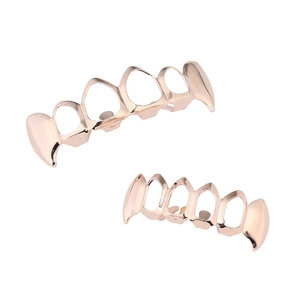 Detail view of rose gold hip hop hollow grillz set with sharp fangs on white background