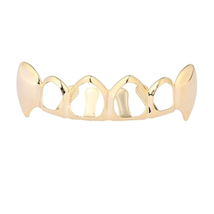 Detail view of gold hollow hip hop grillz with vampire fangs on white background