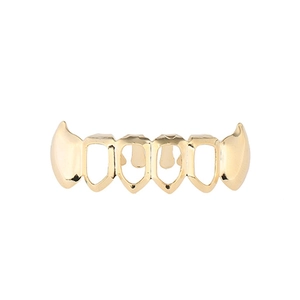 Detail view of gold hip hop grillz featuring sharp hollow fangs and metallic luster