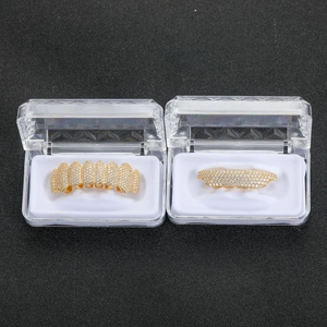 Detailed view of hip hop gold grillz set with pavé cubic zirconia in clear jewelry boxes