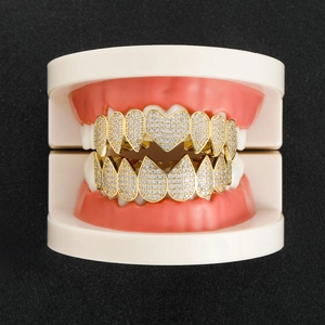 Detailweergave van gouden grillz in hart- en druppelvorm met micro-pave zirkonia