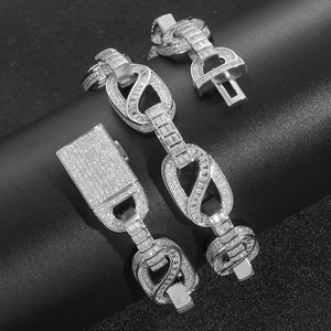 Macro shot of silver hip-hop chain with cubic zirconia stones on a black display stand