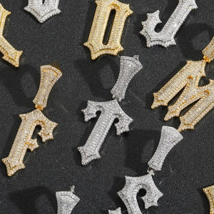 Vista macro di ciondoli hip hop con lettere gotiche e zirconi brillanti incastonati