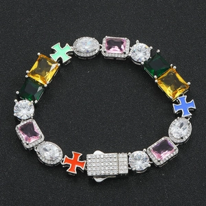 Colorful gemstone cross bracelet with pink and green stones on a black background