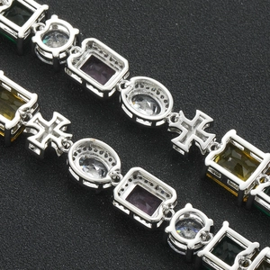 Macro view of silver-tone necklace featuring multi-colored cubic zirconia and cross links