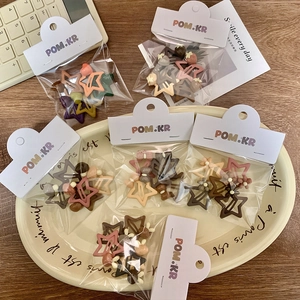 Kawaii star hair clips set in assorted earth tones like cream and pink on a plate