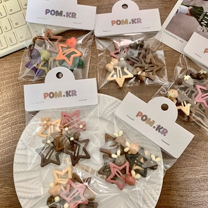 Star-shaped hair clips set with heart and flower charms in warm matte resin colors
