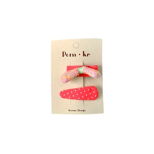 Pink glitter butterfly and red polka dot fabric hair clips for kids on a card