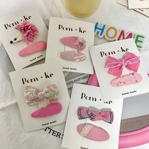Lot de dix barrettes pour filles avec nœuds floraux roses sur carte de présentation