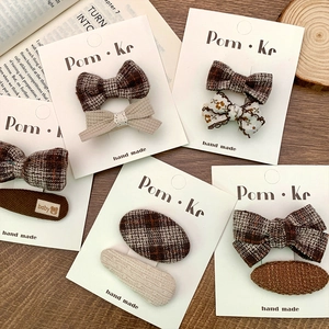 Floral and plaid fabric hair clip set for girls on a white card display