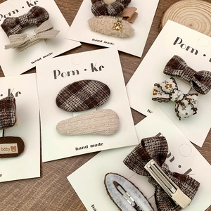 Plaid bow and plush flower hair clips set in brown autumn tones on wood background