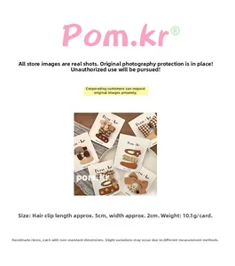 Detailed view of brown bow and floral fabric hair clips on a white display card