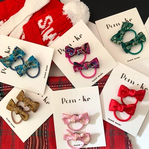 Flat lay of colorful Chinese brocade bow hair clips set for kids with festive decor