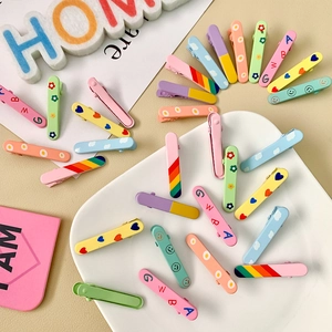 Colorful macaron duckbill hair clips with cartoon prints including rainbow and smiley face