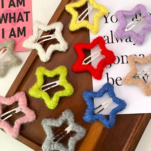 Collezione di fermagli per capelli a stella in maglia colorata su vassoio in legno