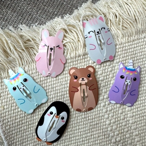 Dettaglio di un set di 6 fermagli per capelli a forma di animali su sfondo intrecciato