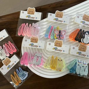 Close-up of cute cartoon animal hair clips and elastic bands in colorful packaging
