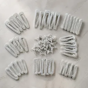 Glitter silver star and geometric hair clips on a wooden surface with card packaging