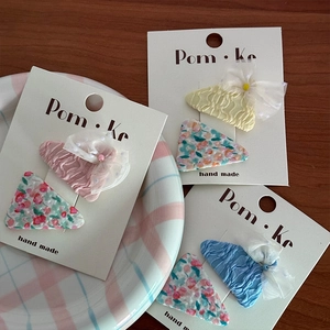 Set floraler Stoff-Haarklammern in Pink Gelb und Blau auf einer Marken-Verpackungskarte