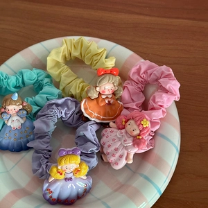 Détail de 5 chouchous princesse de dessin animé sur un plateau en céramique à carreaux