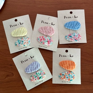 Set di fermagli per capelli in tessuto floreale dai colori vivaci su tavolo rustico