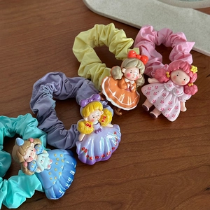 Détail de chouchous en tissu colorés avec de mignons charms de dessin animé en 3D sur bois