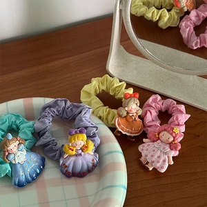 Détail de chouchous colorés avec d'adorables figurines de filles en 3D sur un bureau