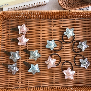Flat lay detail of cute sequined star hair clips and elastic bands for children