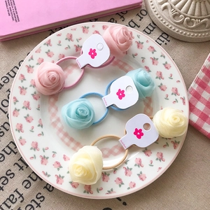 Sweet lace rose flower hair ties in pink, blue, and yellow on a white display card