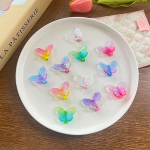 Lot de 11 pinces à cheveux papillon colorées avec effet dégradé sur un plateau blanc