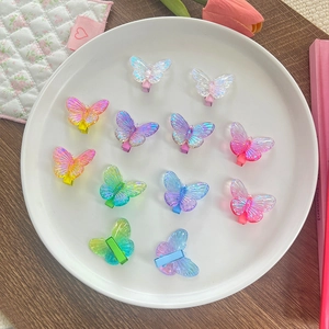 Barrettes papillon translucides colorées avec finition irisée sur une assiette déco