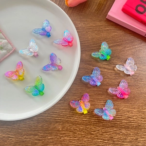Lot de 12 barrettes papillon en résine colorée pour enfants sur une assiette en céramique