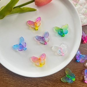 Vue détaillée de barrettes papillon en résine colorée dégradée sur une assiette blanche
