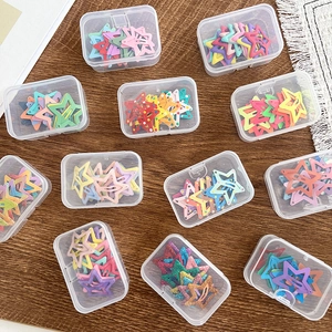 Close-up of colorful star-shaped hair clips in various patterns and clear storage cases