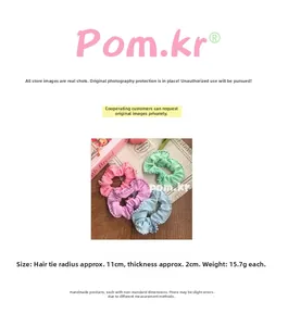 Detail view showing dimensions of pastel scrunchies with white pearls on a soft fabric