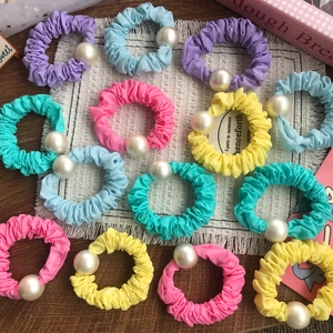 Chouchous colorés avec perles d'imitation en tons pastel sur un tapis à franges