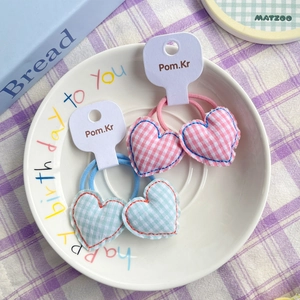 Pink and mint green gingham heart hair ties for girls on a decorative white plate