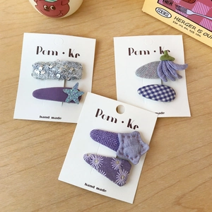 Three pairs of purple fabric plaid hair clips with sequins and embroidery on card